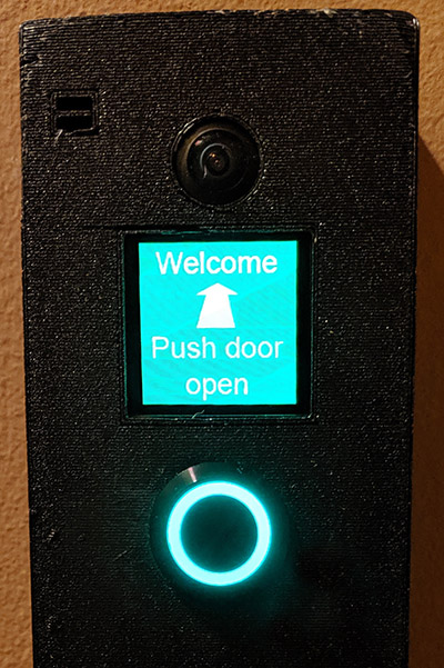 close-up photo of screen on doorbell, which reads "Welcome - Push door open"